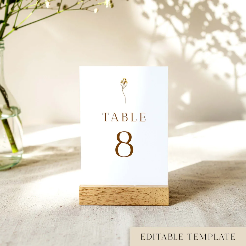 Botanical-inspired "Table 8" number template with a delicate gold floral illustration and modern type. The Goldfields design offers a clean, nature-focused aesthetic. Stress-free editing and A-size printing options.
