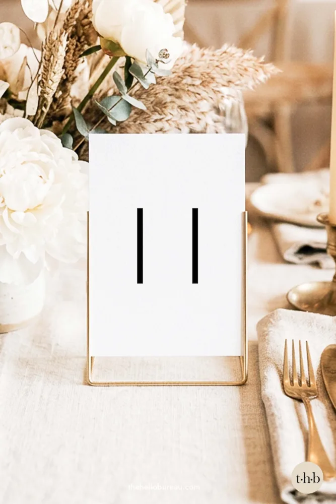 Minimalist free printable wedding table number PDF with "11" in a clean, modern sans-serif font. A sleek and simple DIY design by The Hello Bureau, perfect for industrial, warehouse, or gallery-style receptions.