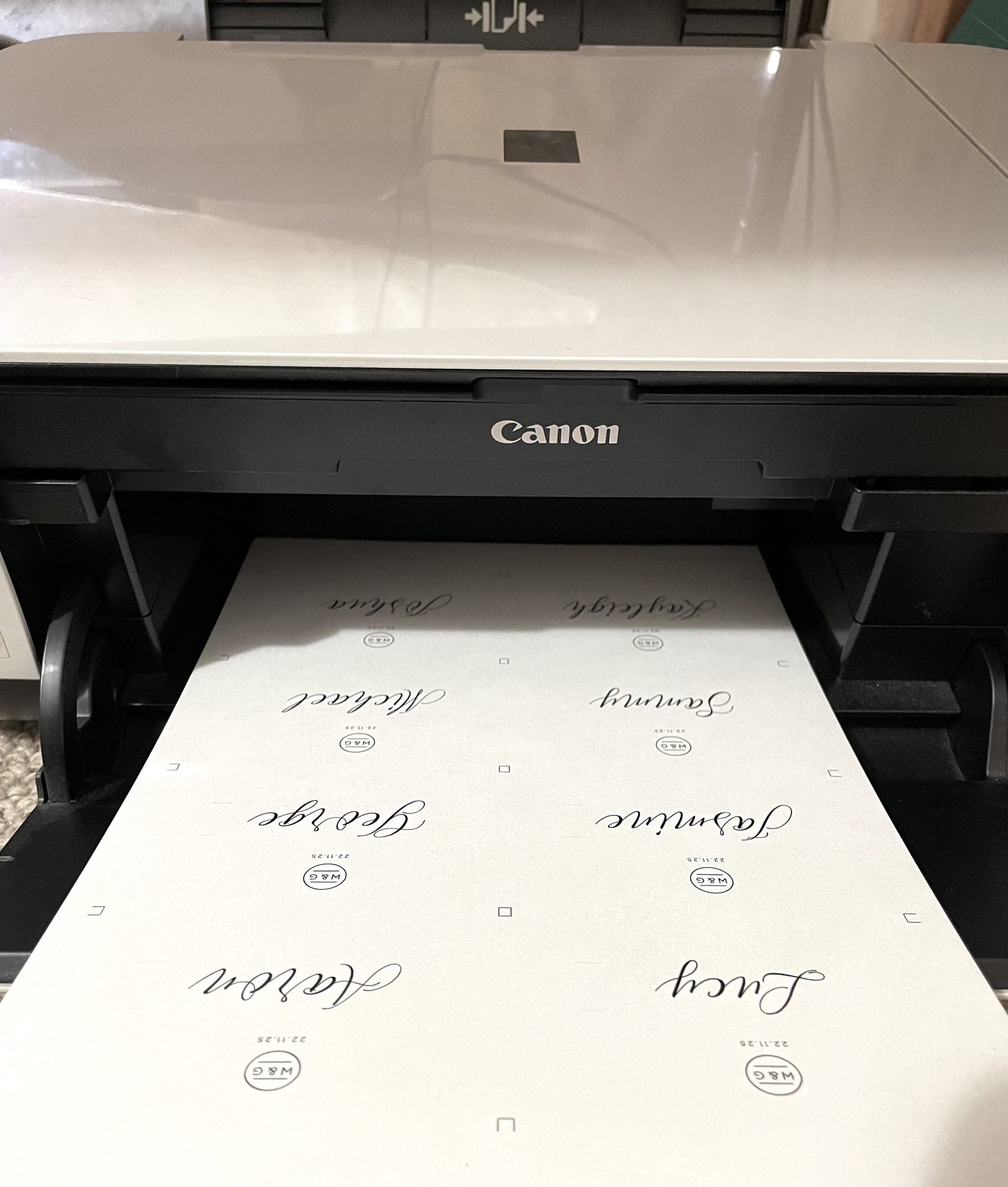 A home printer with a page of printed wedding place cards