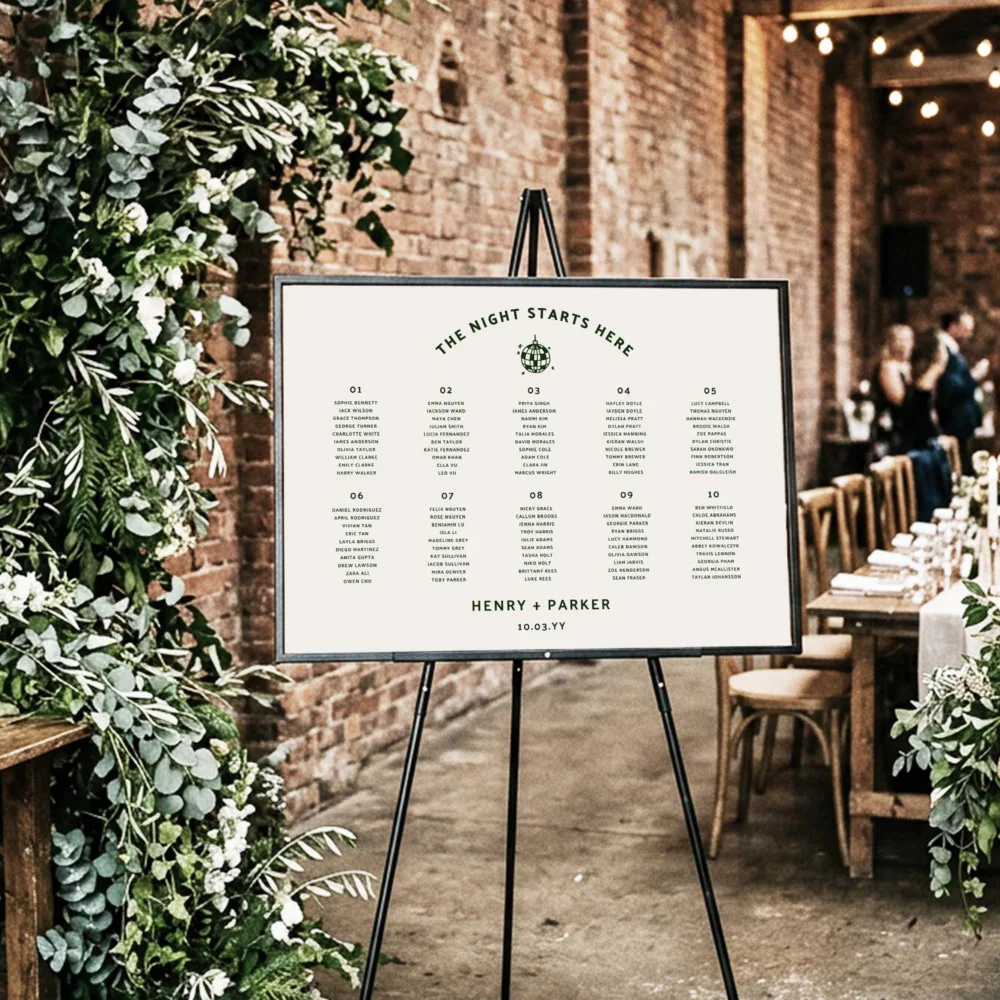 Industrial-chic 10-table wedding seating plan in a landscape orientation. The Lyra design is displayed on a black easel against a rustic brick wall, ideal for warehouse or urban venue styling.