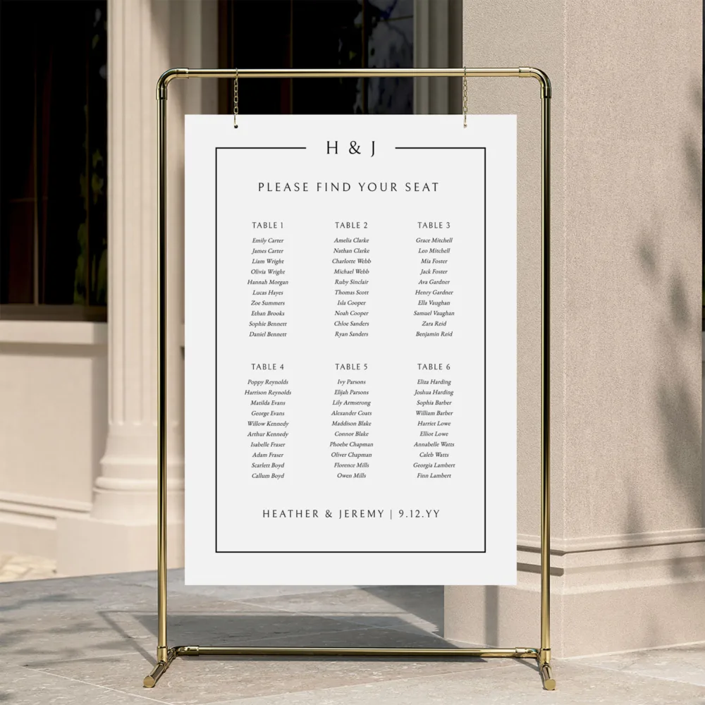 A classic 6-table wedding seating chart with a traditional border, displayed on a gold hanging frame. The Mayfair design by The Hello Bureau shows a clean, portrait layout for small-to-medium wedding receptions.