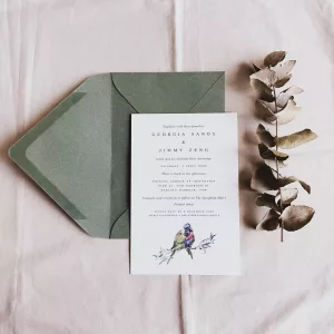 A green envelope with a card and a eucalytpus leaf