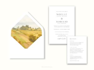 White envelope with a printed liner showing a farm pasture landscape next to wedding invitations.