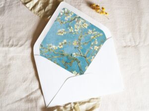 White envelope with a printed liner showing almond blossoms on a blue background.