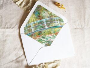 White envelope with a printed liner showing a painted bridge over a pond of water lillies.