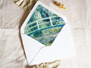 White envelope with a printed liner showing a painted bridge over a pond of water lillies.