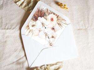 White envelope with a printed liner showing illustrated bohemian florals.