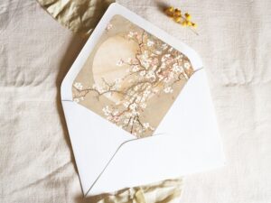 White envelope with a printed liner showing painted Japanese cherry blossoms.