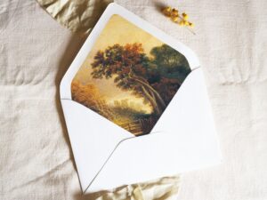 White envelope with a printed liner showing a painted countryside landscape.