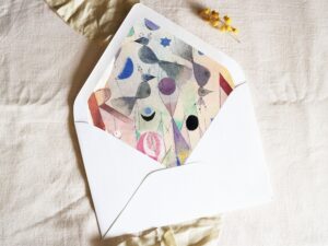 White envelope with a printed liner showing painted abstract birds.