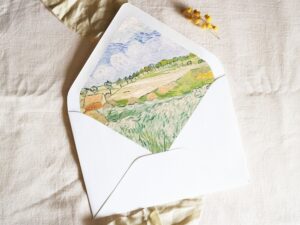 White envelope with a printed liner showing a painted farm landscape.