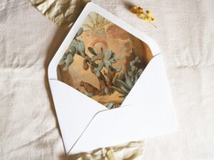 White envelope with a printed liner showing a cactus plant in a desert landscape.