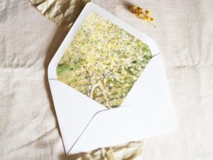 White envelope with a printed liner showing a fruit tree in bloom.