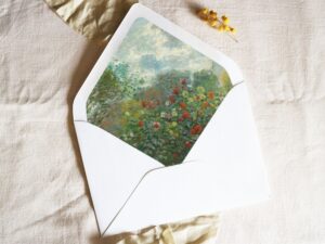 White envelope with a printed liner showing a painted green garden with red flowers.