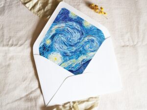 White envelope with a printed liner showing a painted starry night scene.