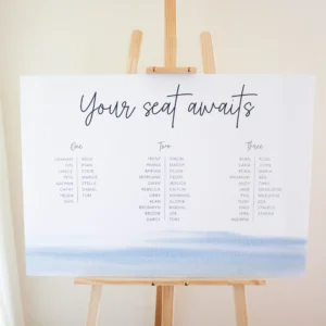 A white and blue wedding seating chart on an easel