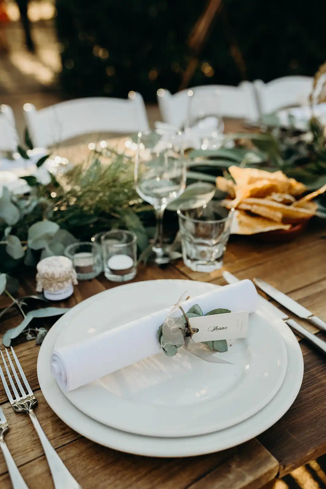 A rolled napkin with a place card on a plate