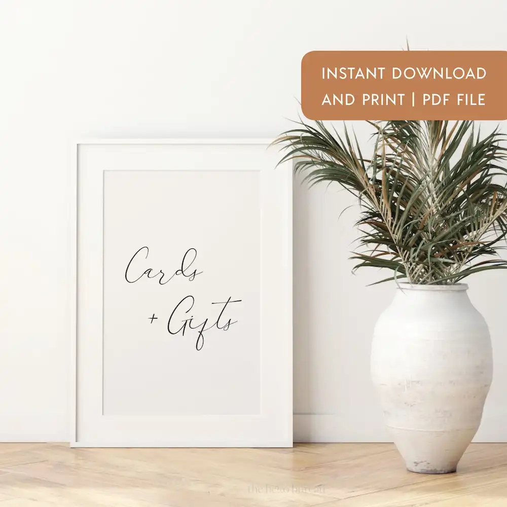 Our free printable cards and gifts sign displayed in a white photo frame on a table