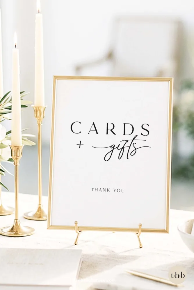 A modern and elegant wedding cards and gifts sign by The Hello Bureau, featuring a mix of modern serif and calligraphy fonts in a gold frame with white taper candles.
