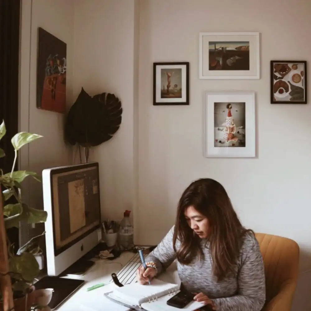 Woman sitting at a desk planning website design concepts