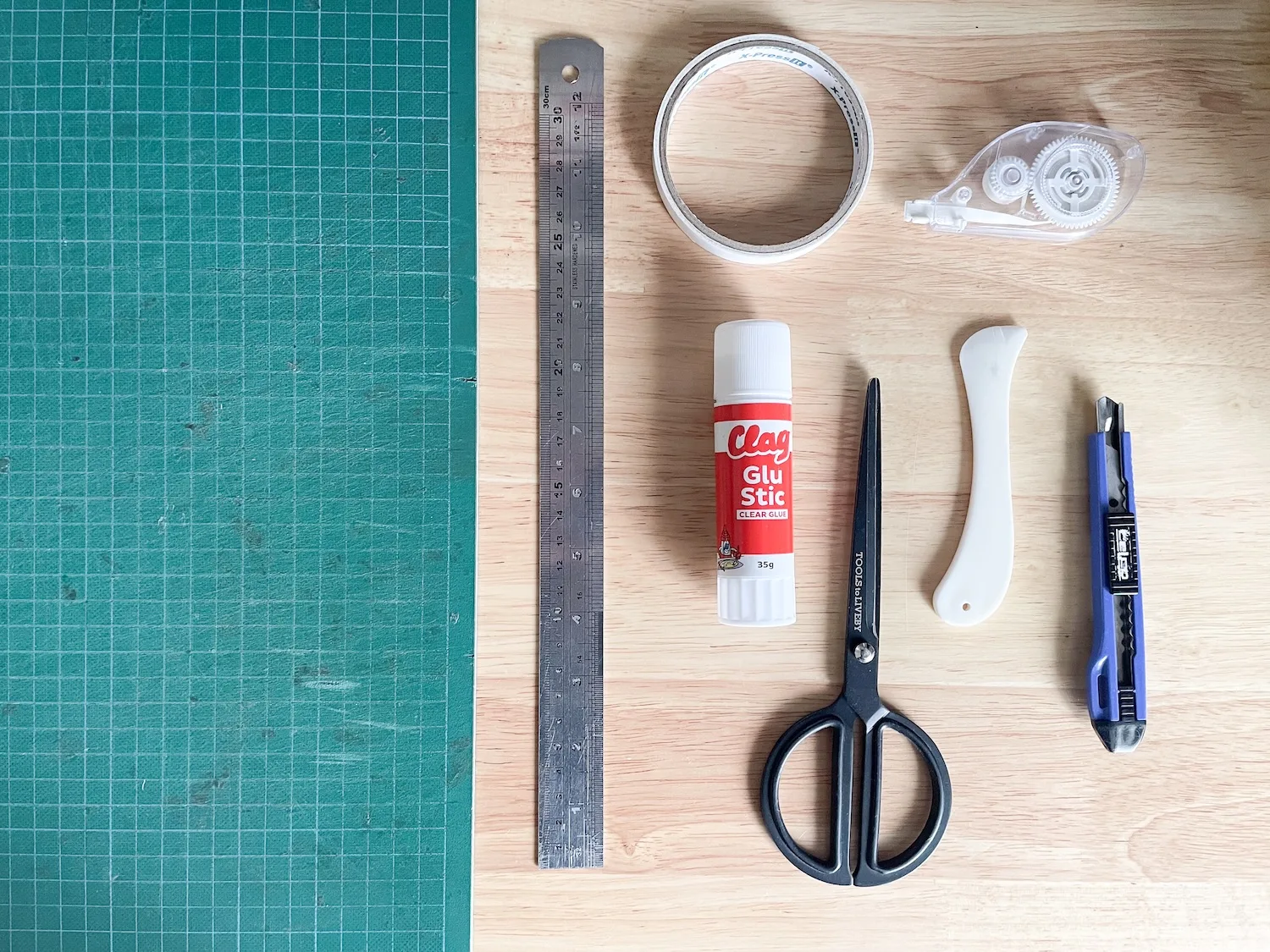 Envelope liner tools including scissors, craft knife, ruler, bone folder, glue stick and tape roller