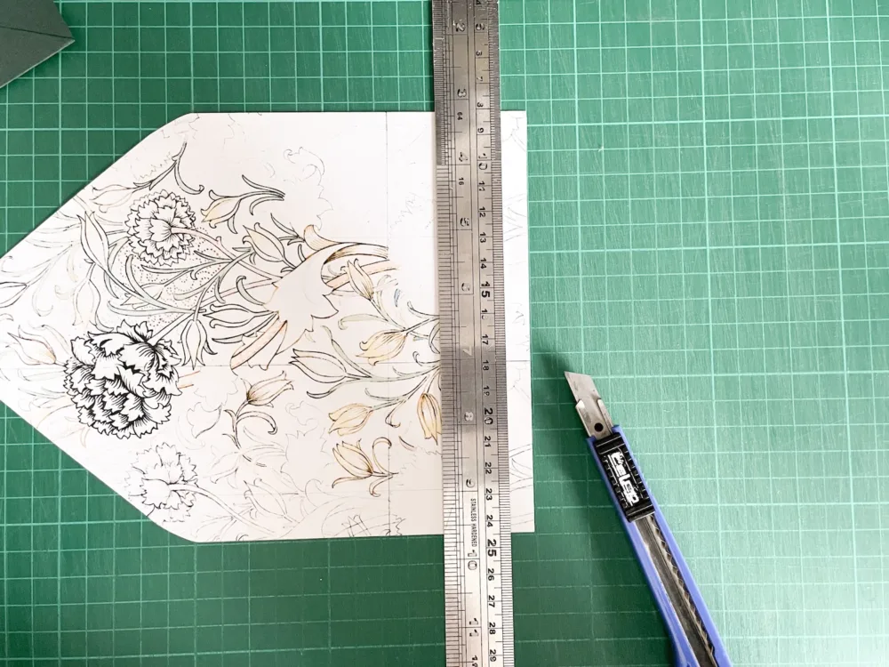 Cutting envelope liner with craft knife and metal ruler on cutting mat