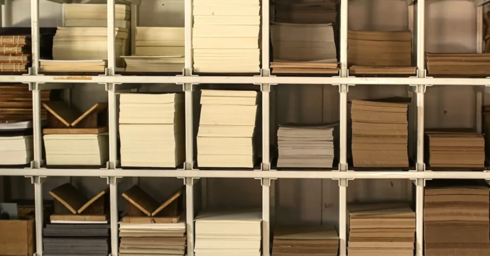 A large shelf with stacks of different paper sizes and colours