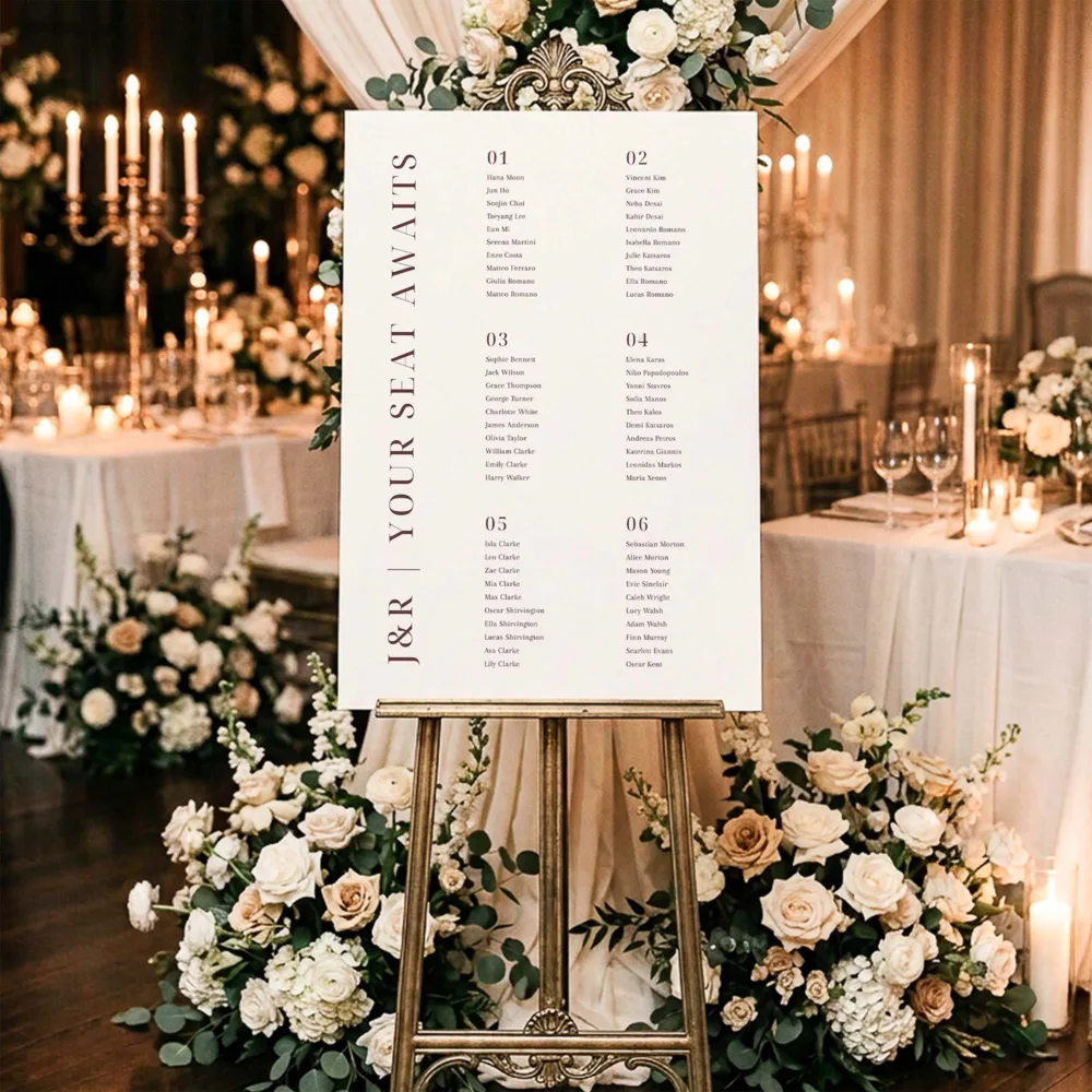 A six-table seating chart on a gold easel at a wedding reception.
