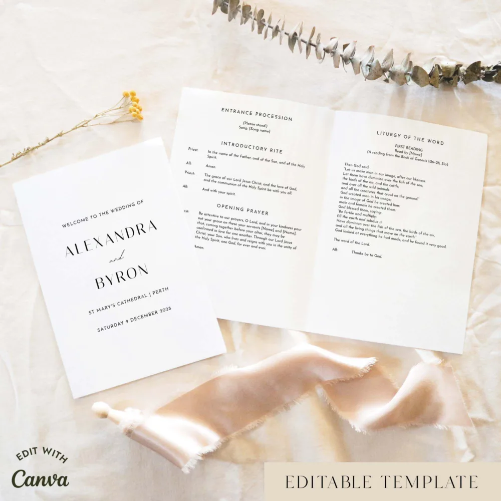 Modern A5 16-page Catholic wedding booklet shown open with the cover beside it, styled on light fabric with dried florals and a soft ribbon.