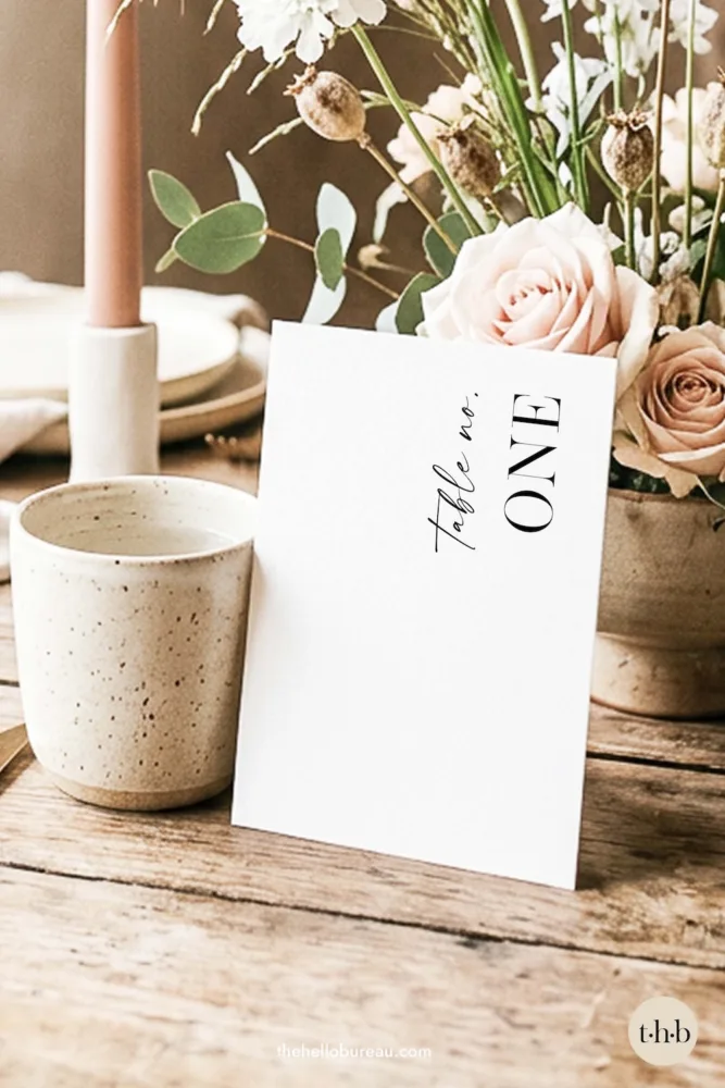 Modern free printable wedding table number PDF featuring "table no. one" in a bold, elegant serif typeface. A timeless and minimalist DIY design that is easy to download, print, and display for a stress-free wedding setup.