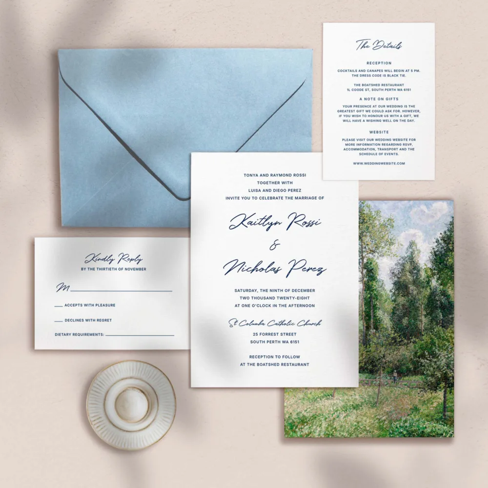 Wedding invitation, details card, RSVP card and envelope on a textured surface.