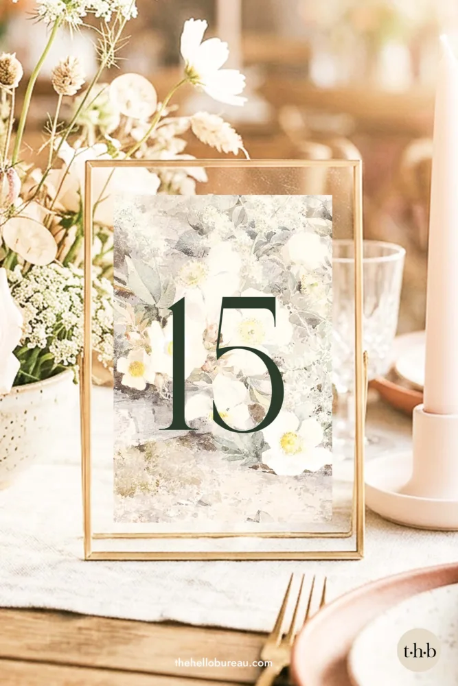Wildrosen fine art table number in a gold floating frame, styled on a romantic wedding table with white florals and candles