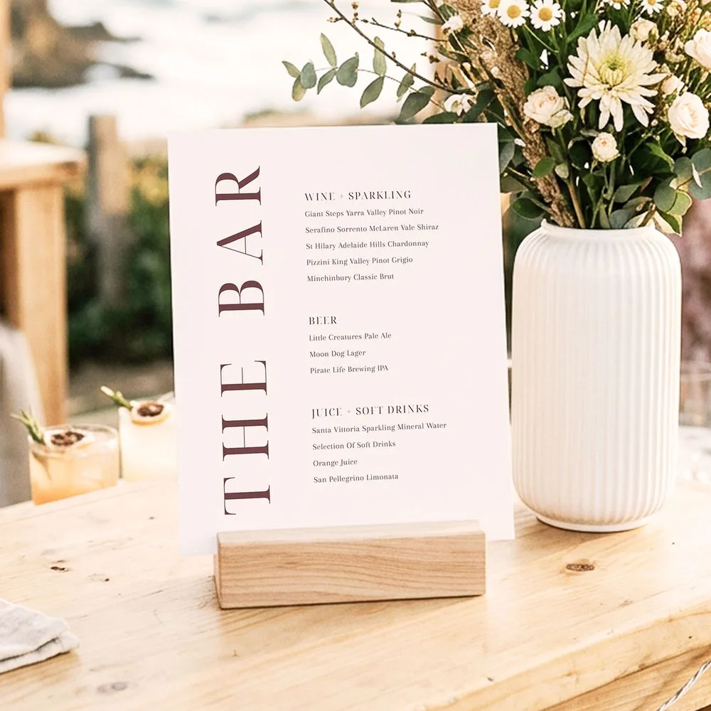 Modern bar sign for wedding reception on a wooden bench